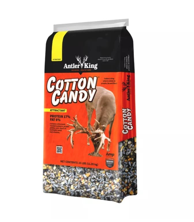 A 25 lb bag of Antler King Cotton Candy deer attractant, red-and-black with a feeding buck on the front and the seed blend showing through a clear window at the bottom.