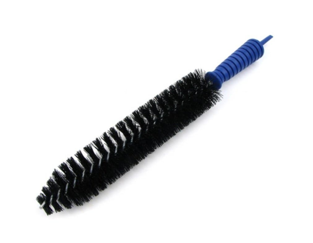 An Arredondo magazine cleaning brush lying diagonally: a long black nylon bristle head twisted onto a wire core, with a ribbed blue handle at the top that tapers into a disassembly spike.