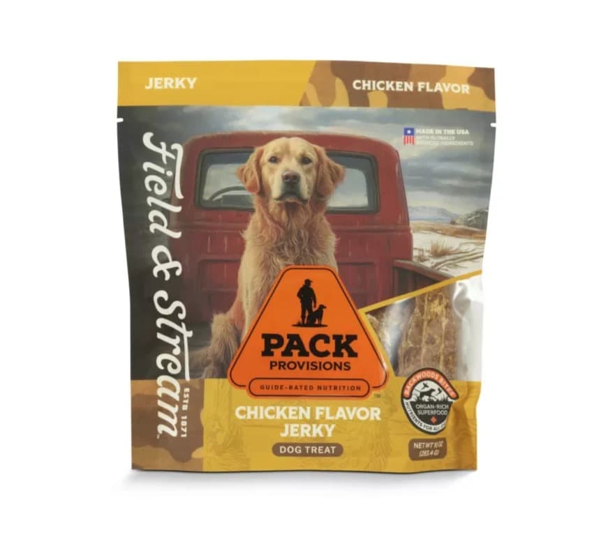 A 10 oz bag of Field & Stream Pack Provisions chicken-flavor jerky dog treats, a golden retriever sitting in the bed of a red pickup on the front, with a window showing the jerky strips.