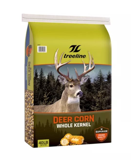 A 40 lb bag of treeline whole-kernel deer corn, a whitetail buck against pines on a green-and-brown bag, with a small pile of corn cobs at the bottom.