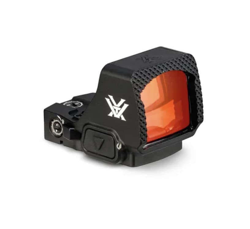 A black Vortex Defender-XL micro red dot from the front-left, the large red-tinted window facing the camera, the Vortex logo on the left side and the textured Fast-Rack face along the top edge.